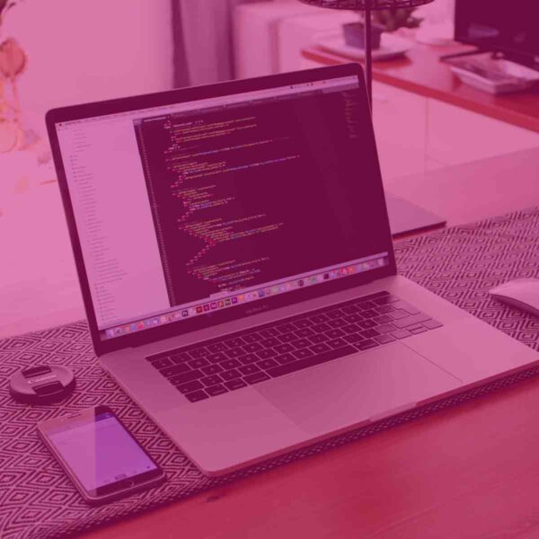 Image of a laptop and phone on a desk with a pink overlay.