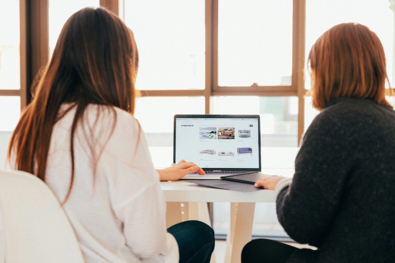 People working on a computer reviewing a website.