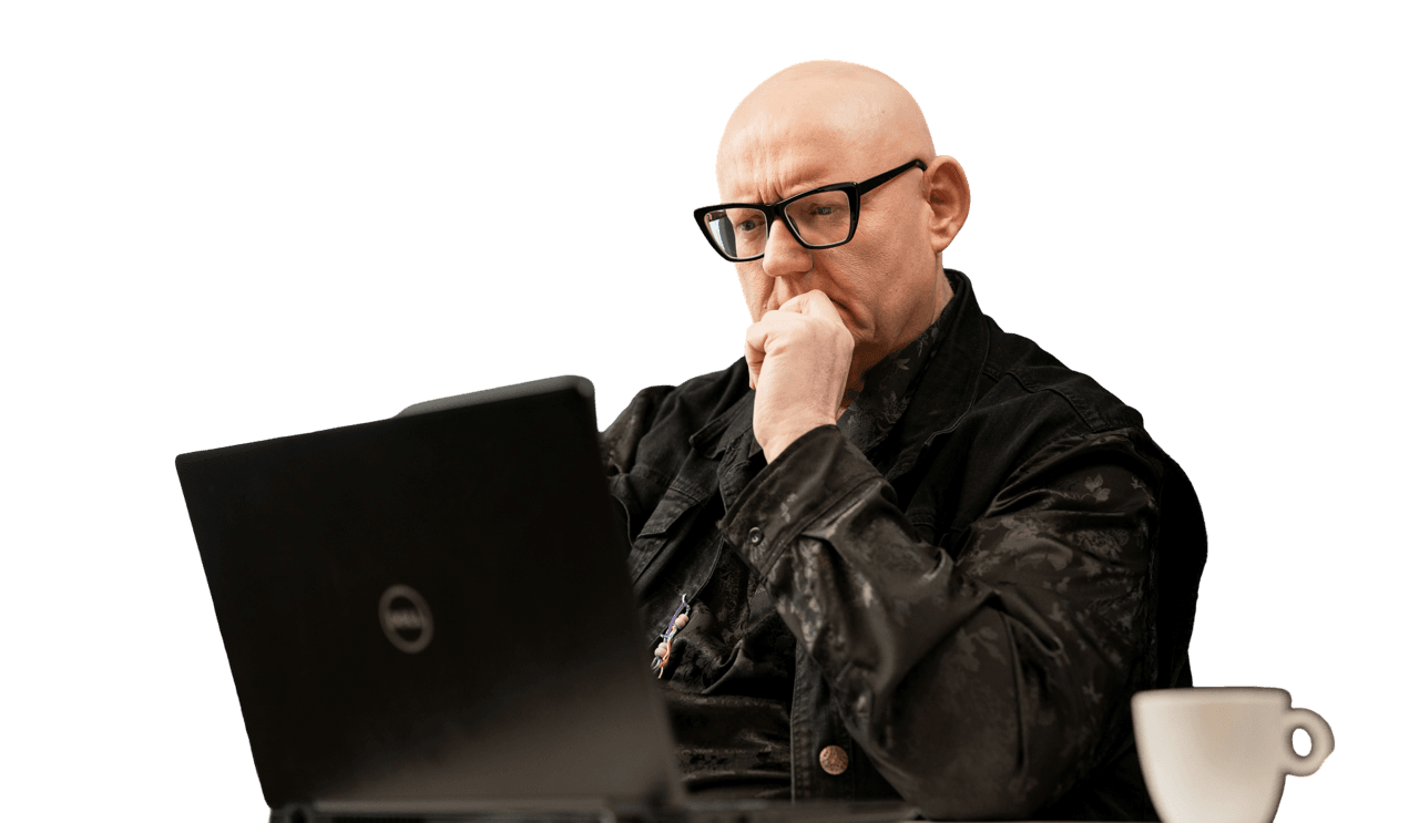 Bold man working on computer, wearing glasses