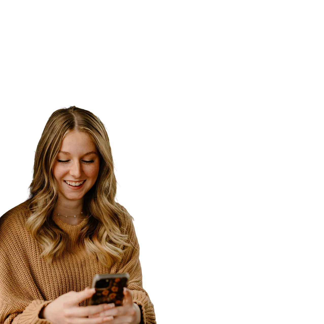 Blonde girl in jumper smiling looking at her phone